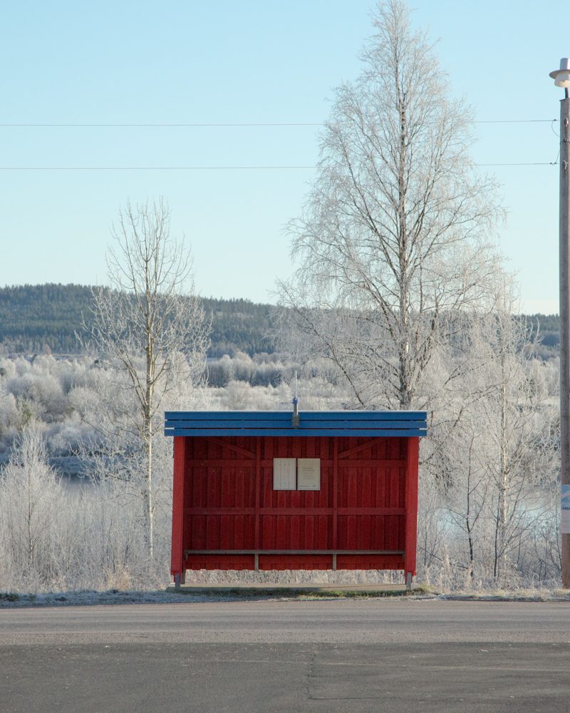 Red bus shelter in a frosty Nordic landscape